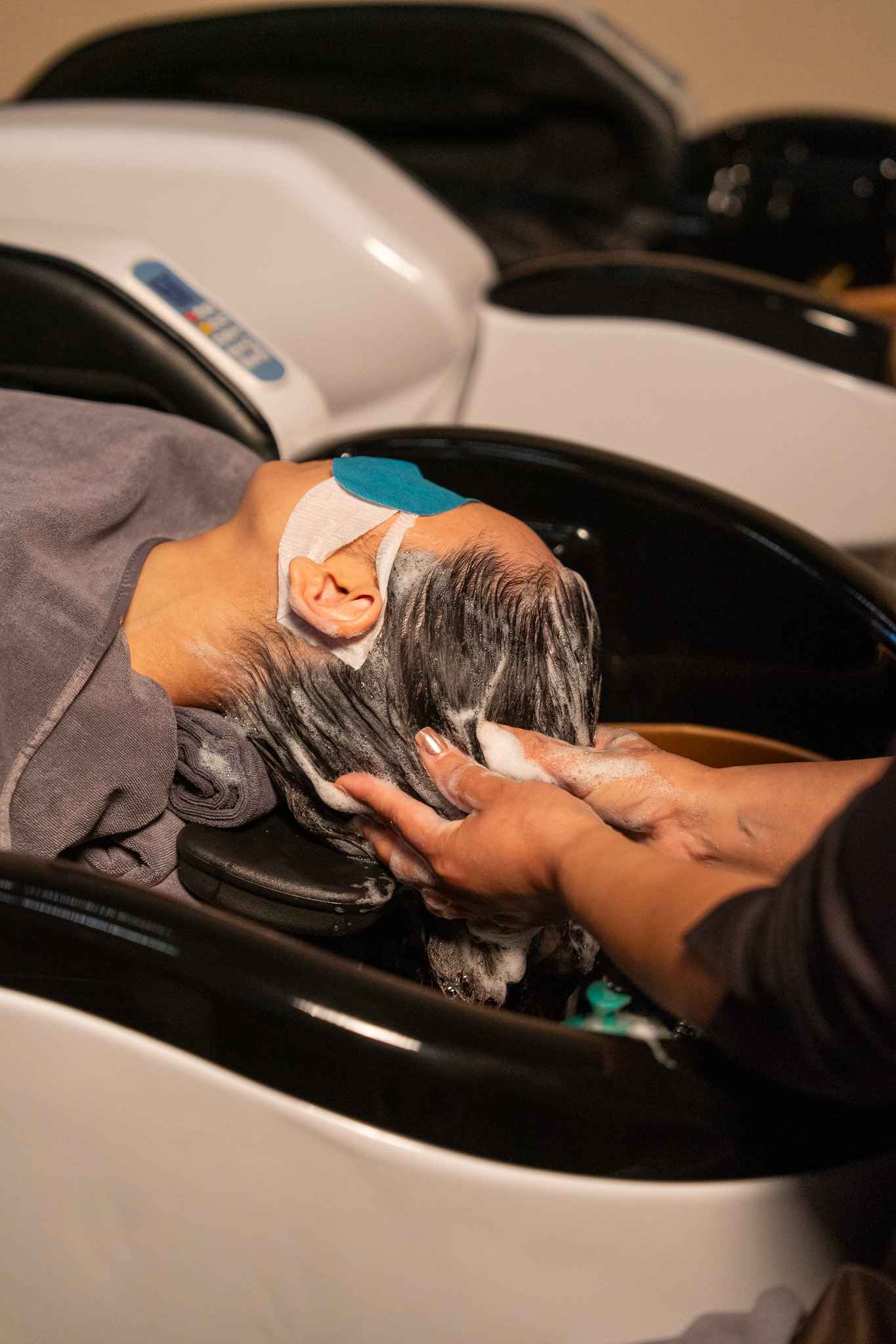 Guest receiving a relaxing head spa treatment at Invita Costa Mesa